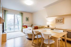 uma sala de estar com uma mesa e cadeiras e um sofá em Citadel Manor Apartment em Budapeste