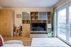 uma sala de estar com televisão e uma grande janela em Citadel Manor Apartment em Budapeste