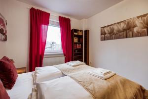 um quarto com uma cama com cortinas vermelhas e uma janela em Citadel Manor Apartment em Budapeste
