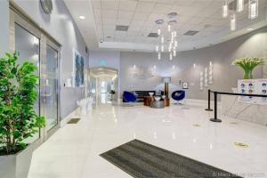 a lobby with white tile floors and blue chairs at 3BR Airbnb Friendly Condo with Ocean View and Balcony in Miami +28 photos