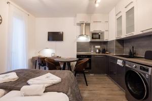 uma cozinha com armários brancos e uma mesa com cadeiras em Central Sphere Apartment em Budapeste
