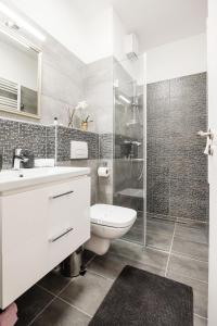 a white bathroom with a toilet and a shower at Central Sphere Apartment in Budapest