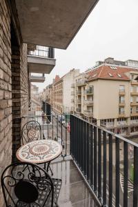 um pátio com uma mesa e cadeiras numa varanda em Central Sphere Apartment em Budapeste