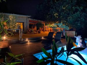 een patio met stoelen en 's nachts verlichting bij Villa Parenthèse in Saint Alban Auriolles