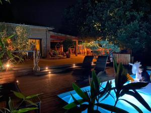 a patio with chairs and lights at night at Villa Parenthèse in Saint Alban Auriolles