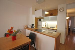 エンプリアブラバにあるBasic Comfort Apartment Gran Reserva 0070のキッチン(木製のカウンタートップ、テーブル付)