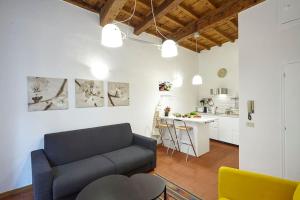 ein Wohnzimmer mit einem blauen Sofa und einer Küche in der Unterkunft Sant'Ambrogio Studio in Florenz