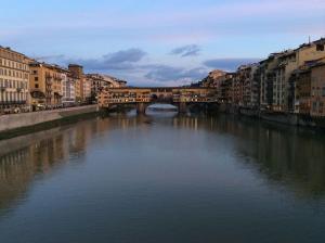 eine Brücke über einen Fluss in einer Stadt mit Gebäuden in der Unterkunft Sant'Ambrogio Studio in Florenz