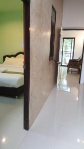 a room with a door open to a bedroom at Raina-Suanpa Lung Sood Farmstay in Suphan Buri