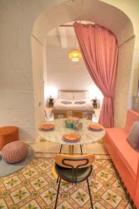 Cette chambre comprend un lit, une table et des chaises. dans l'établissement Impressive & stylish Palazzino in Valletta DDEM1-3, à La Valette