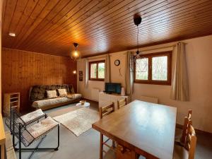 a living room with a wooden ceiling and a table at Vacances COURCHEVEL/les 3 Vallées in Bozel