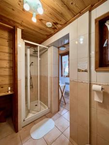 bagno con doccia e porta in vetro di Vacances COURCHEVEL/les 3 Vallées a Bozel