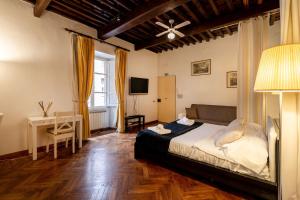 a bedroom with a bed and a desk and a television at Prince's Suite - Budget Rooms & Apt Piazza Del Popolo in Rome