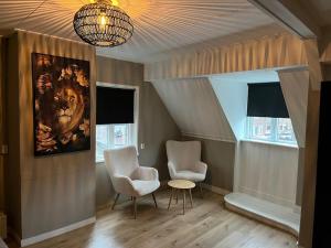 twee stoelen en een tafel in een kamer met een schilderij bij Appartement centrum Leeuwarden in Leeuwarden