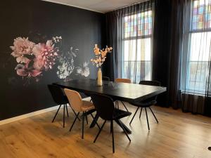 a black dining room table with chairs and a vase with flowers at Appartement centrum Leeuwarden in Leeuwarden +7 photos
