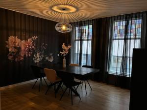 a dining room with a table and chairs and a chandelier at Appartement centrum Leeuwarden in Leeuwarden