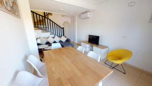 ein Wohnzimmer mit einem Holztisch und weißen Stühlen in der Unterkunft Casa Rosalia - A Murcia Holiday Rentals Property in Torre-Pacheco
