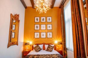 Schlafzimmer mit einem Bett, einem Spiegel und einem Kronleuchter in der Unterkunft Ambassade Hotel in Amsterdam