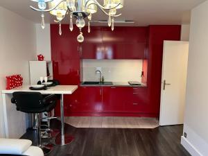 kuchnia z czerwonymi szafkami i białym blatem w obiekcie Appt 4P, parking, Disney direct, Vallée Village w mieście Serris