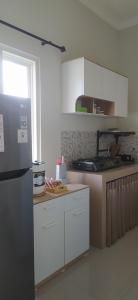 a kitchen with white cabinets and a refrigerator at Villa Kayana EE6 - 3 Bedrooms in Batu