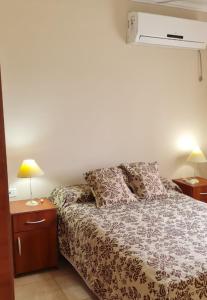 1 dormitorio con 1 cama con 2 mesitas de noche y 2 lámparas en Departamentos Blanc en Colón