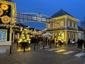 um centro comercial com luzes de Natal e árvores de Natal em Appt 4P, parking, Disney direct, Vallée Village em Serris