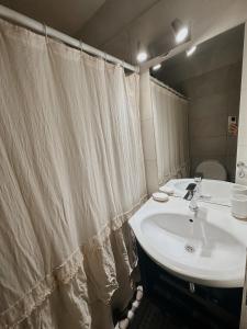 uma casa de banho com um lavatório e uma cortina de chuveiro em Departamento confortable em Mendoza
