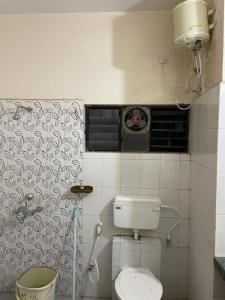 a bathroom with a toilet and a clock on the wall at Samruddhi S1 homestay villa swimming or S3,S20 in Nagpur