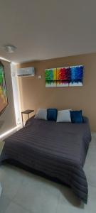 a large bed in a bedroom with two paintings on the wall at Centro Carlos Paz 1 dormitorio in Villa Carlos Paz +8 photos