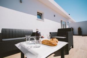 einen Tisch mit einer Flasche Wein und Brot darauf in der Unterkunft Best Houses 30 - Terrace Peniche in Peniche