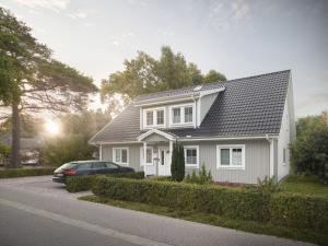 uma casa branca com um carro estacionado em frente dela em Schwedenglück Prerow em Prerow