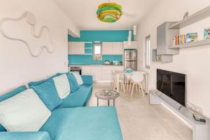 ein Wohnzimmer mit einer blauen Couch und einer Küche in der Unterkunft Villa Iremía in Ampelas