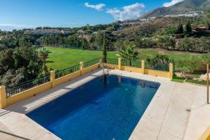 a swimming pool on a balcony with a view of a golf course at VB Amapolas 2BDR Sea views & relax in Benalmádena