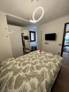 a bedroom with a bed and a television in it at Gin Sole Apartment in Artogne