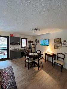 a living room with a table and chairs and a kitchen at Gin Sole Apartment in Artogne