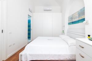 um quarto branco com uma cama e uma janela em HC Home Claudia em Cagliari