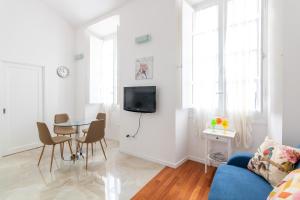 uma sala de estar com um sofá azul e uma mesa em HC Home Claudia em Cagliari