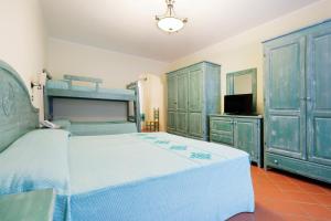 una camera con letto e alcuni armadi blu di Hotel Baia Aranzos a Pittulongu