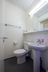 a bathroom with a white toilet and a sink at Beit Hall in London