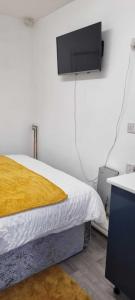een slaapkamer met een bed en een tv aan de muur bij 1 bed studio in Luton