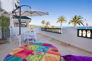 a patio with a table and an umbrella at Appartement avec Terrasse VUE MER in La Marsa