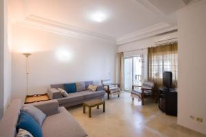 a living room with a couch and a tv at Appartement avec Terrasse VUE MER in La Marsa