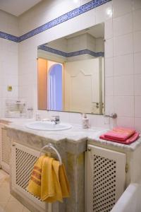 a bathroom with a sink and a mirror at Appartement avec Terrasse VUE MER in La Marsa