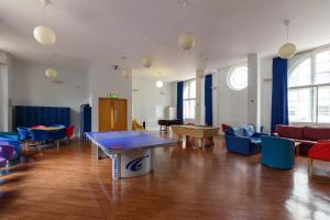 a living room with a ping pong table and chairs at Beit Hall in London