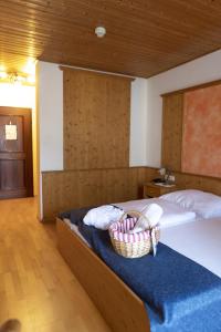 ein Schlafzimmer mit einem Bett und einem Korb darauf in der Unterkunft Wellnesshotel Paradiesquelle in Puchberg am Schneeberg