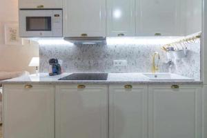 uma cozinha branca com um lavatório e um micro-ondas em Judería de Sevilla I Luxury Apartments em Sevilha