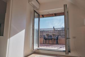 ミラノにあるSant’Andrea Penthouse by Montenapoleone Livingのガラスのスライドドアからバルコニー(テーブル付)へアクセスできます。