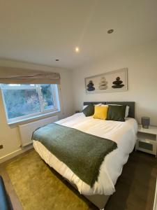 ein Schlafzimmer mit einem großen Bett und einem Fenster in der Unterkunft Cosy North London 2 Bed Apartment in Woodside Park- Close to Station and Central London in Totteridge