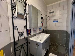 ein kleines Bad mit einem Waschbecken und einem Spiegel in der Unterkunft Maison de l'Horloge in Riorges