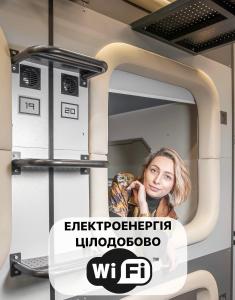 una mujer sentada en una cama en una habitación de hospital en AV-2 capsule hotel en Kiev